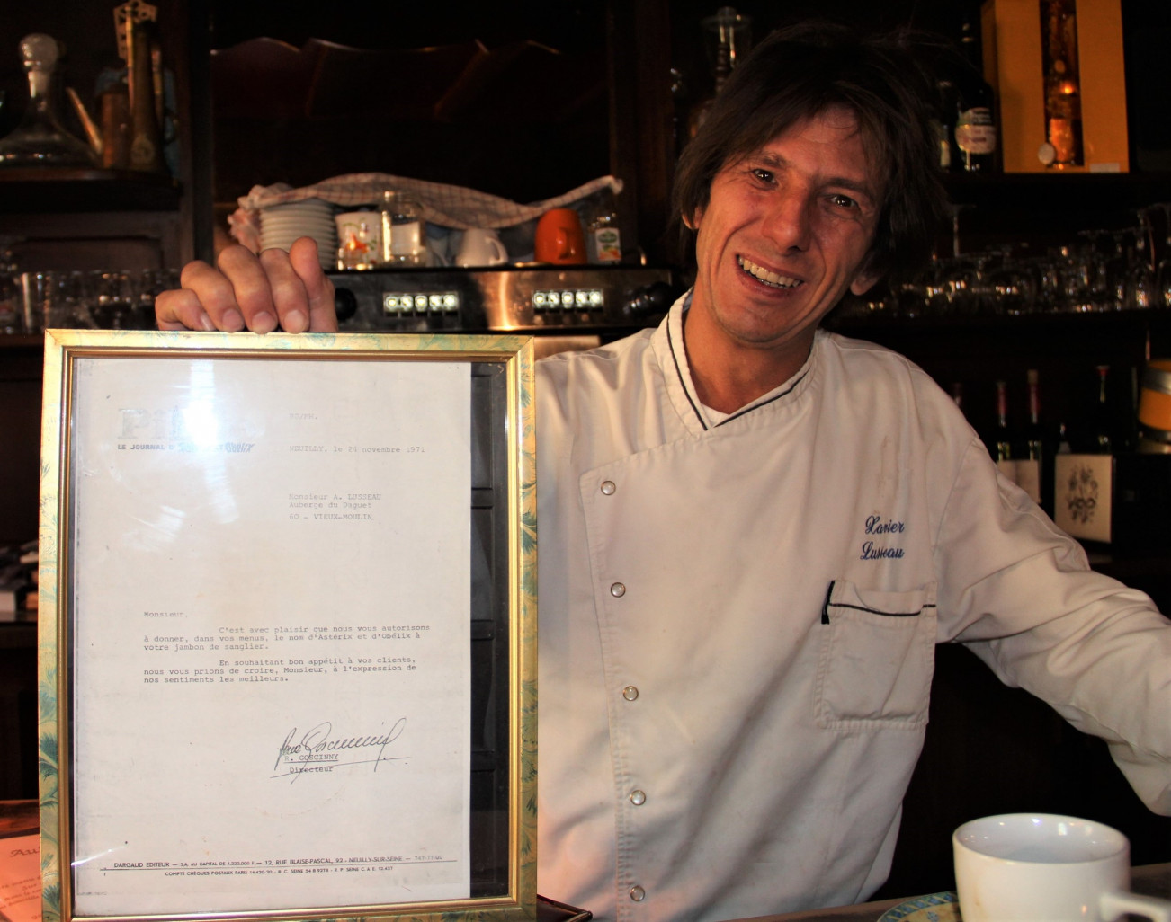 Xavier Lusseau tient une lettre de René Goscinny autorisant le restaurant à utiliser l’appellation « Jambon Astérix et Obélix » dans ses menus. (© Aletheia Press / L. Brémont)