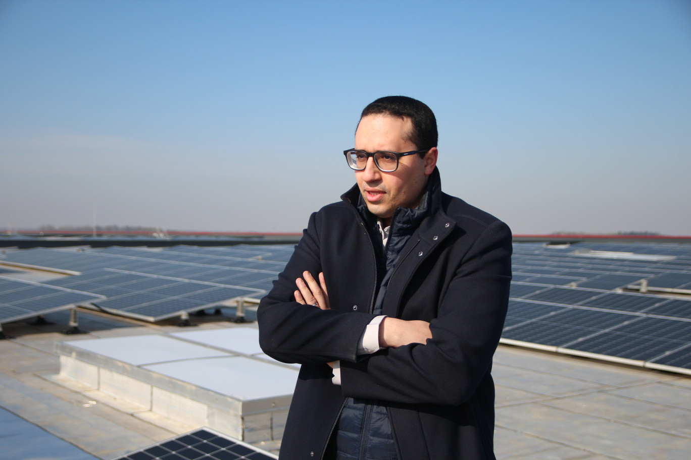 Youssef Mansouri, devant la centrale photovoltaïque située sur le toit de l'entrepôt de Deka Immobilien, exploité par le groupe SeD. (© Aletheia Press / B.Delabre)
